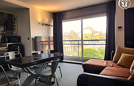 Pièce à vivre avec canapé d'angle 4 places, TV 100cm, espace repas 4 personnes avec cuisine équipée et 2 lits 90x190cm superposés escamotables. Vue sur la place de la poste. City Break n°G622559 Le Touquet-Paris-Plage - Pas-de-Calais - Pièce à vivre avec canapé d'angle 4 places, TV 100cm, espace repas 4 personnes avec cuisine équipée et 2 lits 90x190cm superposés escamotables. Vue sur la place de la poste.