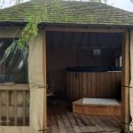 Kiosque en c&egrave;dre abritant le bain nordique, situ&eacute; pr&egrave;s de la rivi&egrave;re, commun aux g&icirc;tes