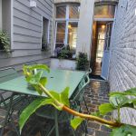 Cour int&eacute;rieure avec salon de jardin et barbecue &eacute;lectrique sans vis &agrave; vis
